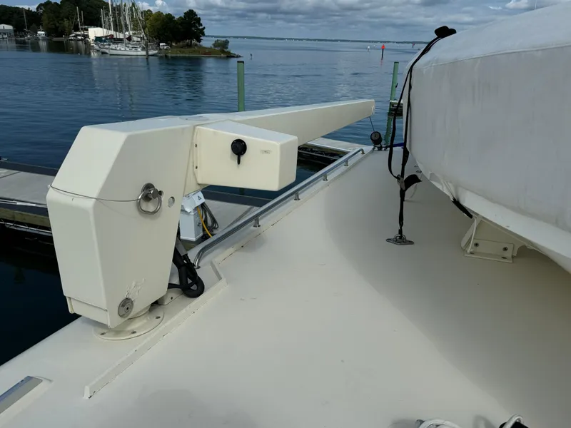 Slide: The Image of 2003 Dettling 51 Express Cruiser deck with davit system, docked by calm waters. - 23