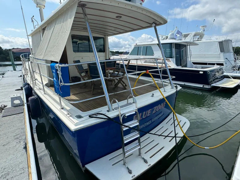 Slide: The Image of 2003 Dettling 51 Express Cruiser docked at marina, featuring spacious deck and blue hull. - 3
