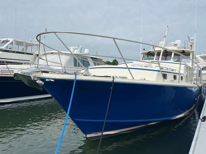 Slide: The Image of 2003 Dettling 51 Express Cruiser docked at marina, featuring sleek blue hull design. - 4