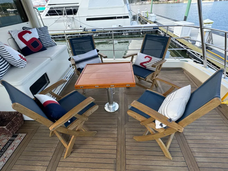 Slide: The Image of Outdoor seating area on 2003 Dettling 51 Express Cruiser with wooden chairs and nautical cushions. - 7