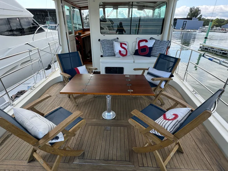 Slide: The Image of 2003 Dettling 51 Express Cruiser deck with chairs, table, and nautical-themed cushions. - 8
