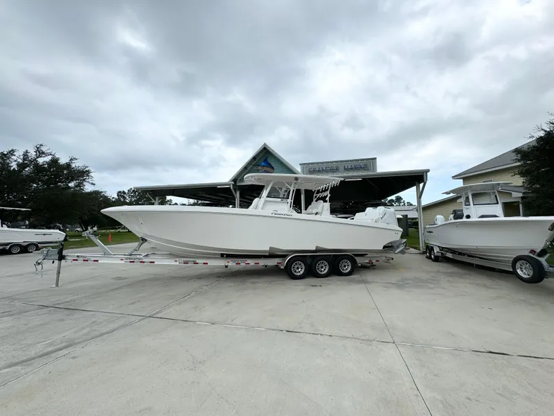 The Image of 2025 Fountain 34TE boat on trailer at dealership under cloudy sky. - 1