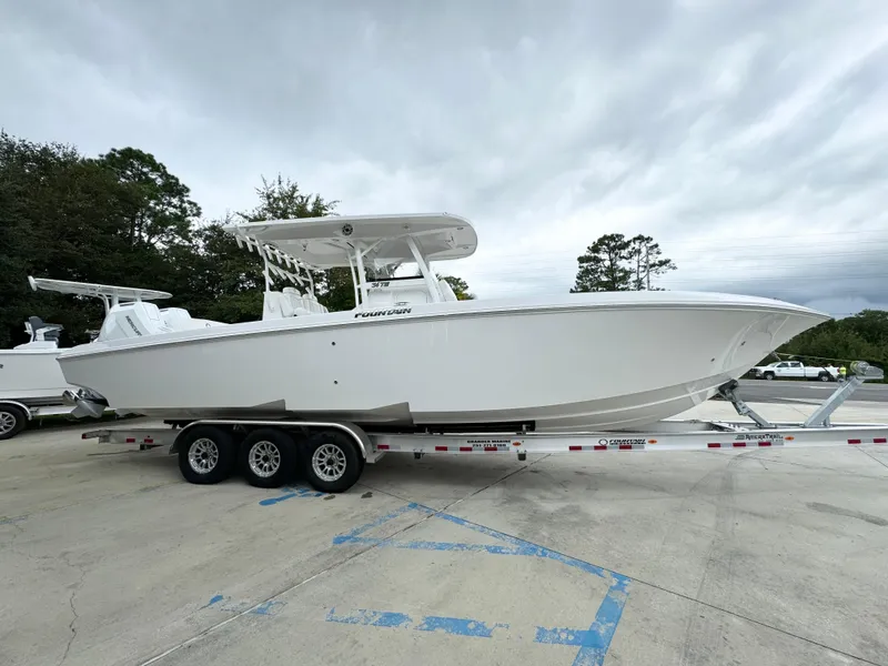 Slide: The Image of 2025 Fountain 34TE boat on trailer, parked outdoors, cloudy sky background. - 10