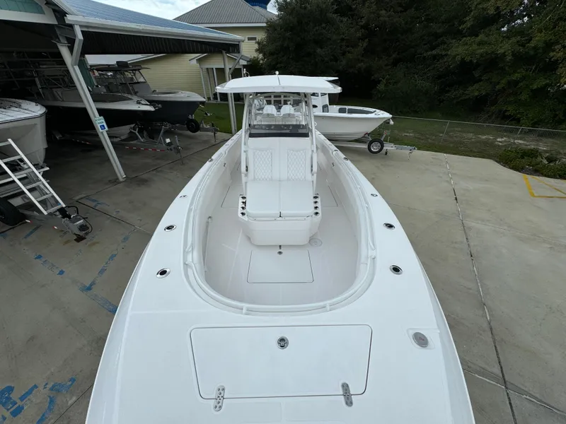 Slide: The Image of 2025 Fountain 34TE boat, sleek white design, docked outdoors. - 19