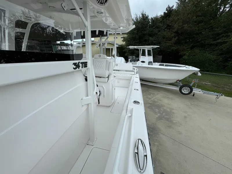 Slide: The Image of 2025 Fountain 34TE boat, sleek white design, parked on a trailer. - 23