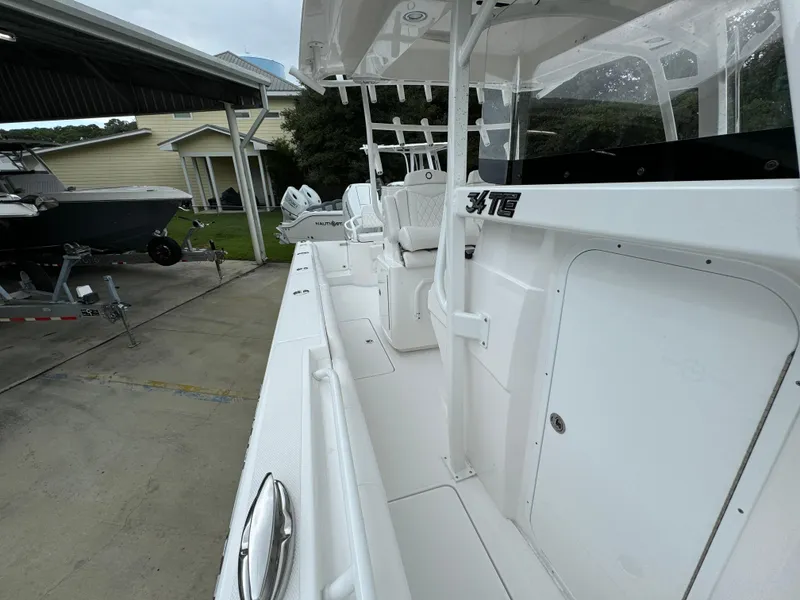 Slide: The Image of 2025 Fountain 34TE boat docked, showcasing sleek white design and spacious deck. - 24