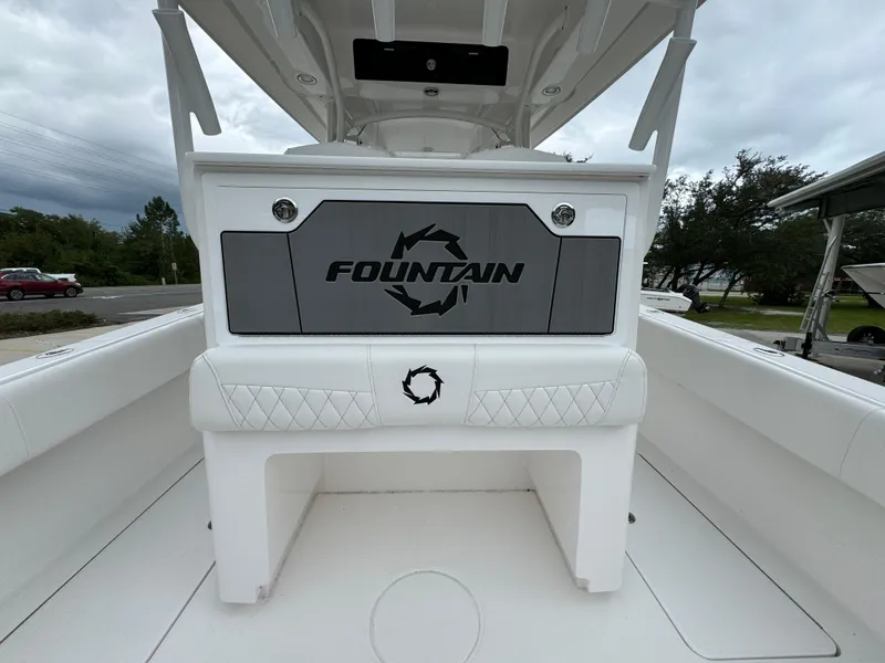 Slide: The Image of 2025 Fountain 34TE boat interior with logo, white seating, and overcast sky. - 33