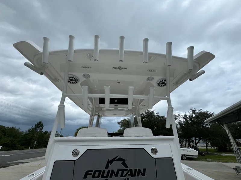 Slide: The Image of 2025 Fountain 34TE boat with T-top and rod holders under cloudy sky. - 34