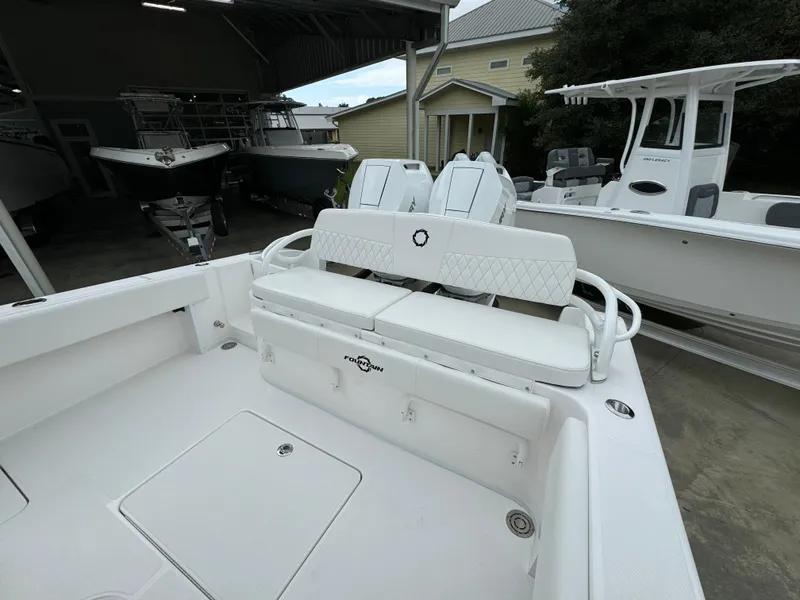 Slide: The Image of 2025 Fountain 34TE boat interior with white seating and storage compartments. - 35