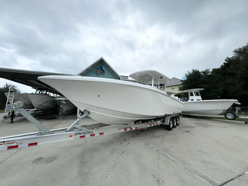 Slide: The Image of 2025 Fountain 34TE boat on trailer, parked outdoors under cloudy sky. - 4