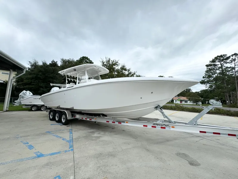 Slide: The Image of 2025 Fountain 34TE boat on trailer, parked outdoors under cloudy sky. - 8