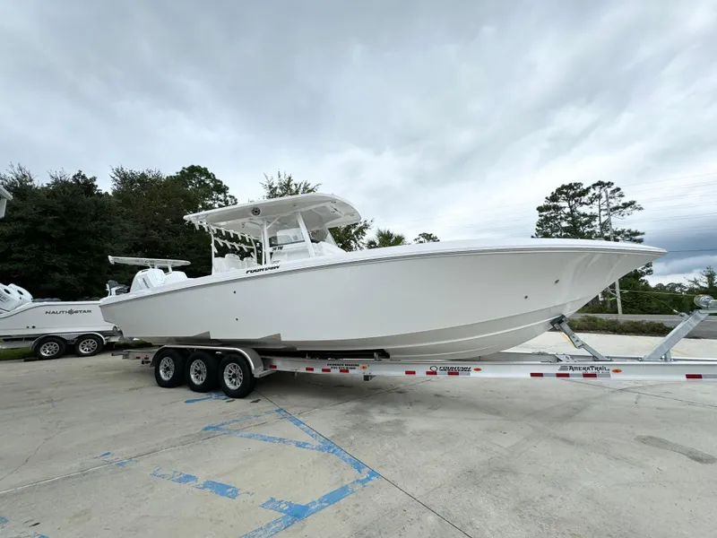 Slide: The Image of 2025 Fountain 34TE boat on trailer, parked outdoors under cloudy sky. - 9