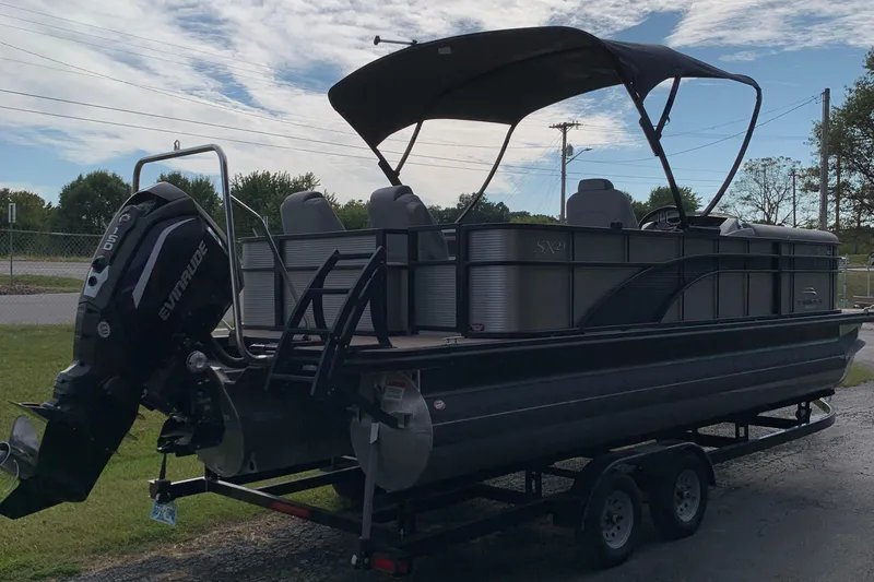 Slide: The Image of 2020 Bennington SXP 23 SBRXP pontoon boat on trailer, featuring Evinrude outboard motor. - 4
