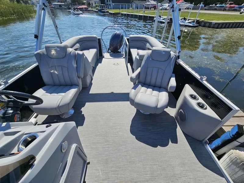 Slide: The Image of 2023 Bennington 24 SSR pontoon boat interior with plush seating on a sunny day. - 10