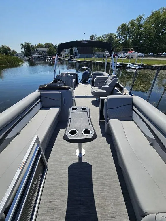 Slide: The Image of 2023 Bennington 24 SSR pontoon boat with spacious seating and sleek design on a calm waterway. - 2