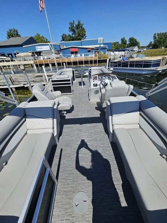 Slide: The Image of 2023 Bennington 24 SSR pontoon boat with spacious seating and modern design at a marina. - 3