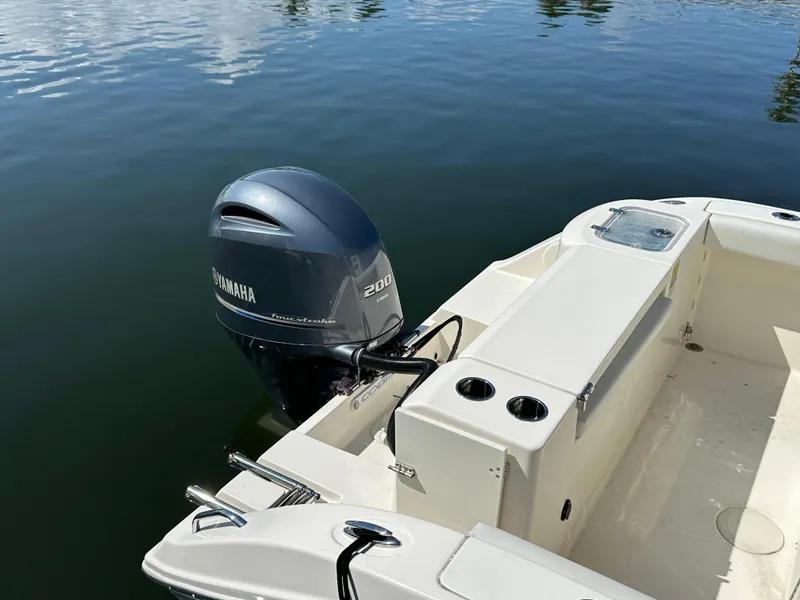 Slide: The Image of 2023 Cobia 220 Center Console boat with Yamaha 200 engine on calm water. - 15