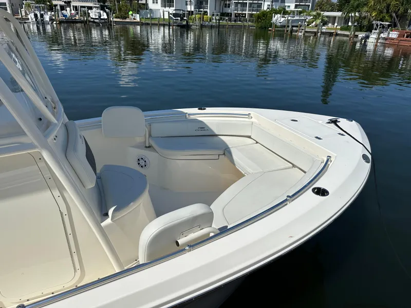Slide: The Image of 2023 Cobia 220 Center Console boat on calm water, featuring spacious seating and sleek design. - 17