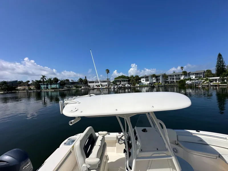 Slide: The Image of 2023 Cobia 220 Center Console boat on calm water with clear blue sky. - 20