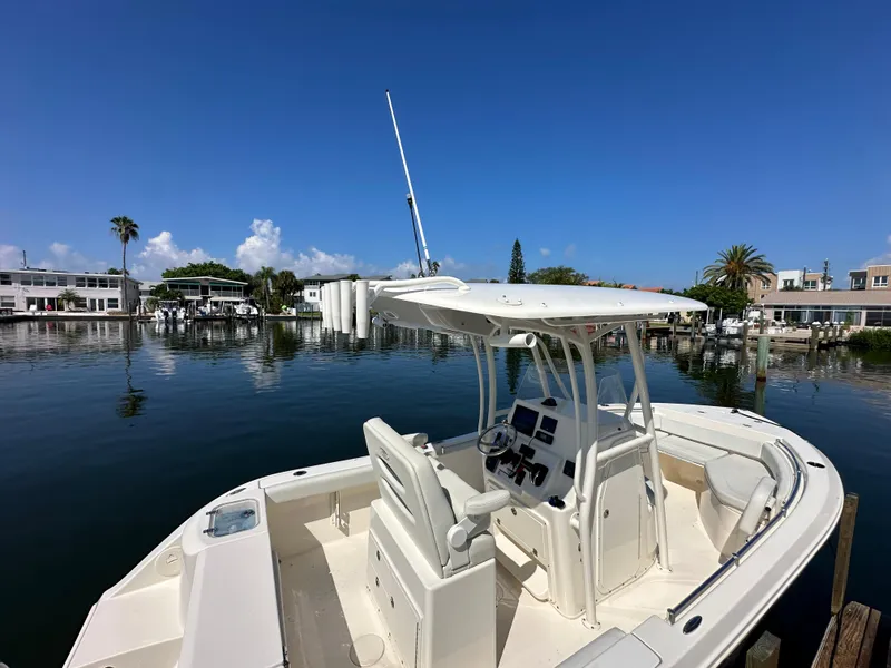 Slide: The Image of 2023 Cobia 220 Center Console boat docked in a scenic marina. - 21