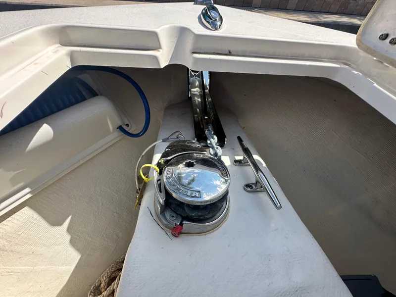 Slide: The Image of 2023 Cobia 220 Center Console boat anchor compartment with winch and cleat. - 24
