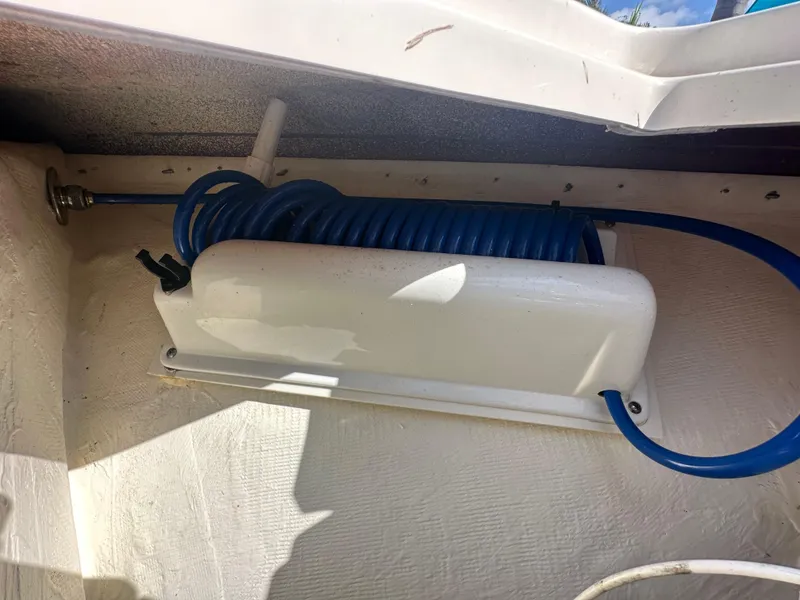 Slide: The Image of Blue coiled hose in 2023 Cobia 220 Center Console boat compartment. - 25