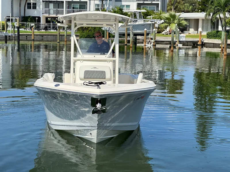 Slide: The Image of 2023 Cobia 220 Center Console boat on calm water near docks. - 3