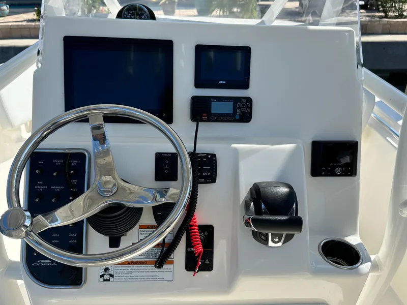Slide: The Image of 2023 Cobia 220 Center Console dashboard with steering wheel and electronic controls. - 43