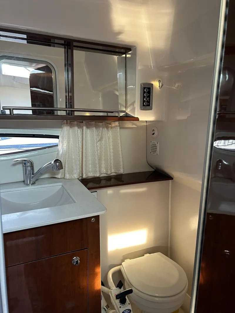 Slide: The Image of 2014 Four Winns Vista 275 bathroom with sink, mirror, and toilet. - 11
