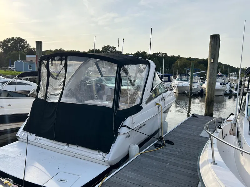 Slide: The Image of 2014 Four Winns Vista 275 boat docked at a marina, rear view. - 2