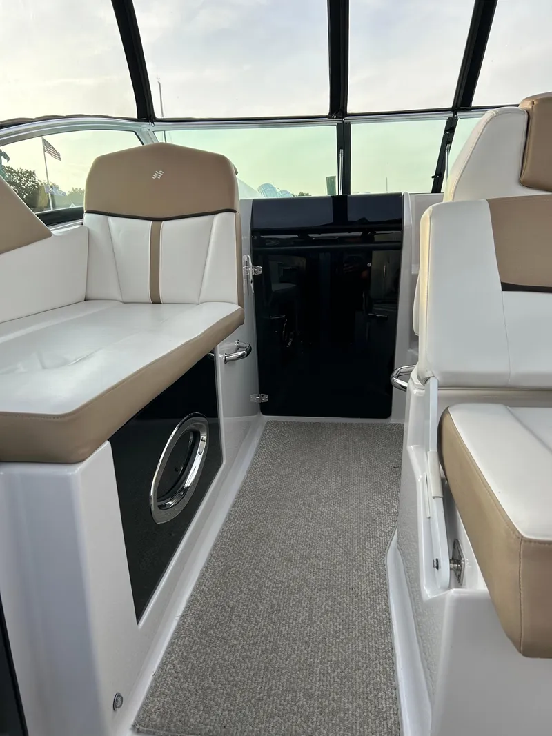 Slide: The Image of 2014 Four Winns Vista 275 interior with beige and white seating, carpeted floor, and sleek design. - 21