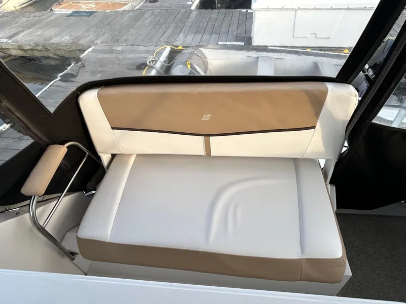 Slide: The Image of 2014 Four Winns Vista 275 boat interior with beige and white cushioned seating. - 23