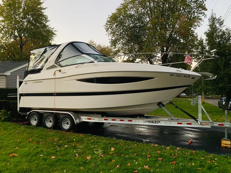 Slide: The Image of 2014 Four Winns Vista 275 boat on a trailer, parked on grass. - 26
