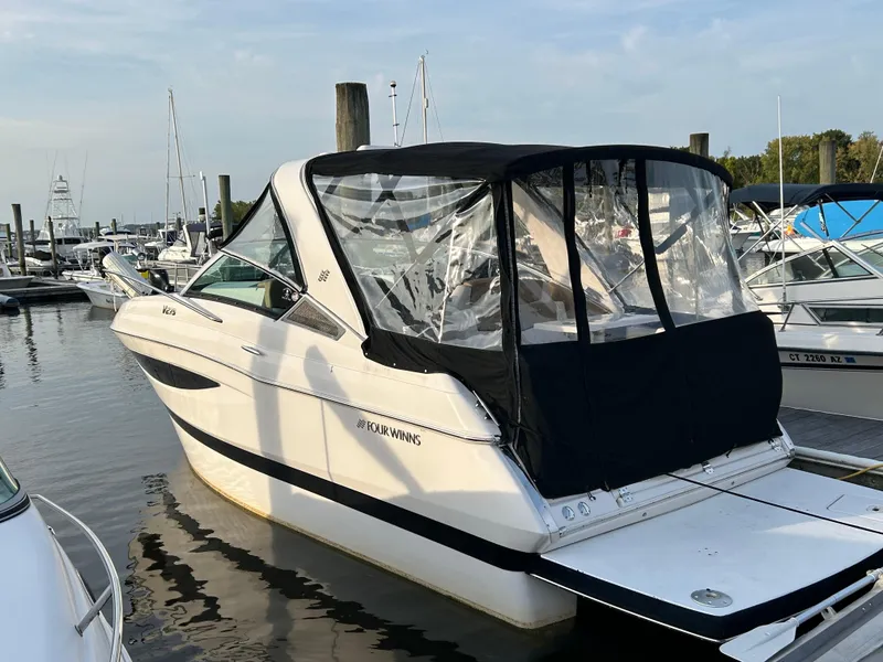 Slide: The Image of 2014 Four Winns Vista 275 boat docked at marina, featuring black canopy and sleek design. - 3