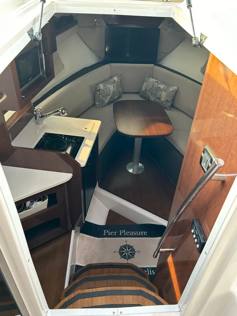 Slide: The Image of Interior of 2014 Four Winns Vista 275 boat with cozy seating and compact kitchen area. - 4