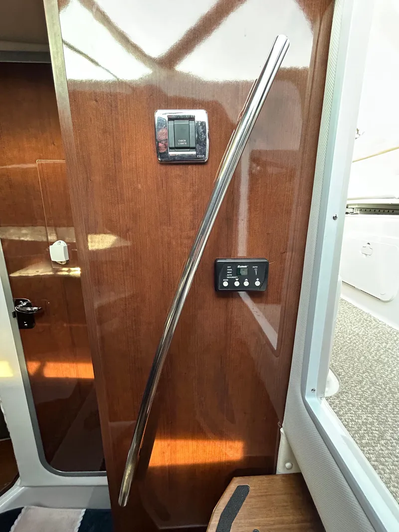 Slide: The Image of 2014 Four Winns Vista 275 interior with wood paneling and control switches. - 5