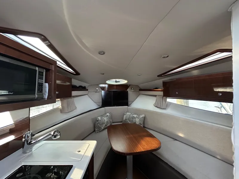 Slide: The Image of 2014 Four Winns Vista 275 cabin interior with kitchenette, dining area, and modern amenities. - 7