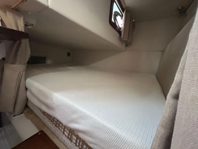 Slide: The Image of 2014 Four Winns Vista 275 cabin interior with a cozy bed and window. - 9