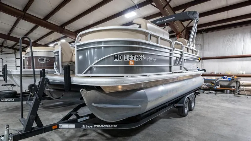 The Image of 2021 Sun Tracker Party Barge 20 DLX pontoon boat on trailer in indoor storage. - 0
