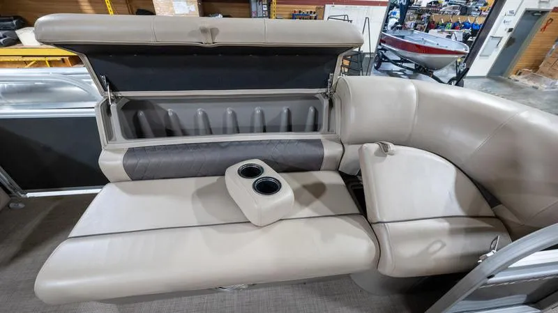 Slide: The Image of 2021 Sun Tracker Party Barge 20 DLX interior seating with storage and cup holders. - 2