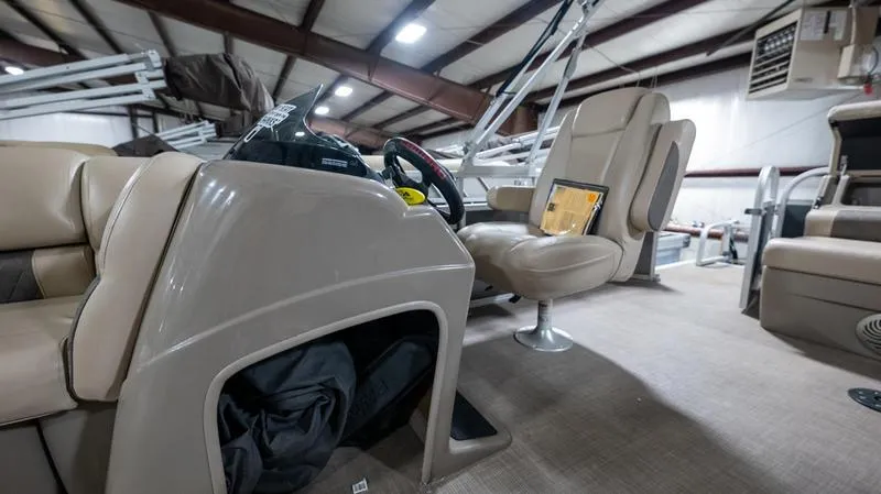 Slide: The Image of 2021 Sun Tracker Party Barge 20 DLX interior with beige seating and steering console. - 6