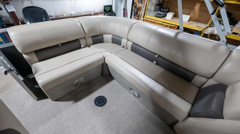Slide: The Image of 2021 Sun Tracker Party Barge 20 DLX interior with beige seating and storage compartments. - 7