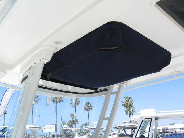 Slide: The Image of Edgewater 280 CC 2018 boat canopy with blue cover, marina background. - 14