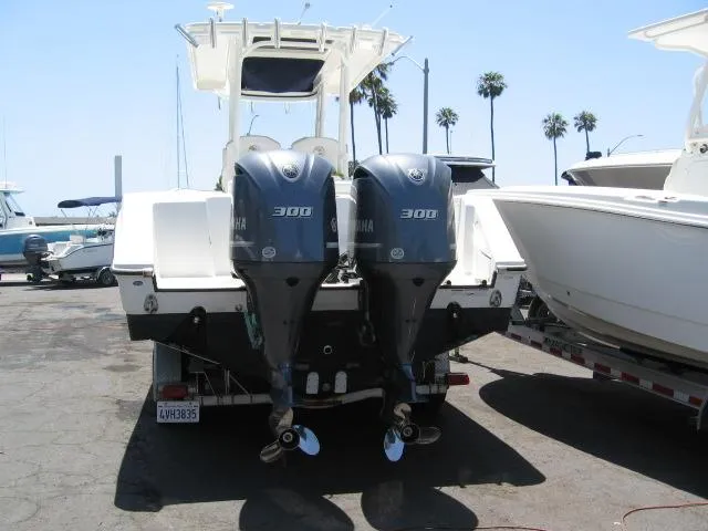 Slide: The Image of 2018 Edgewater 280 CC boat with twin Yamaha 300 engines, docked at marina. - 2