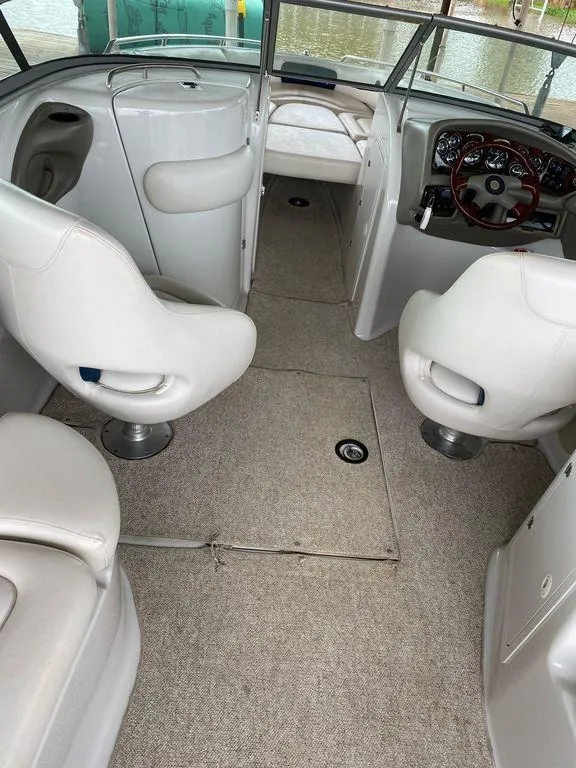 Slide: The Image of Interior of 2003 Crownline 270 BR boat with white seating and steering wheel. - 11