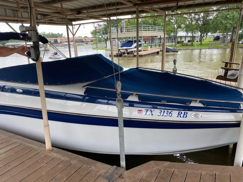 Slide: The Image of 2003 Crownline 270 BR boat docked with blue cover on a lake. - 16