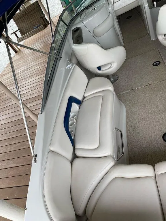 Slide: The Image of 2003 Crownline 270 BR boat interior with white seating and cup holders. - 19