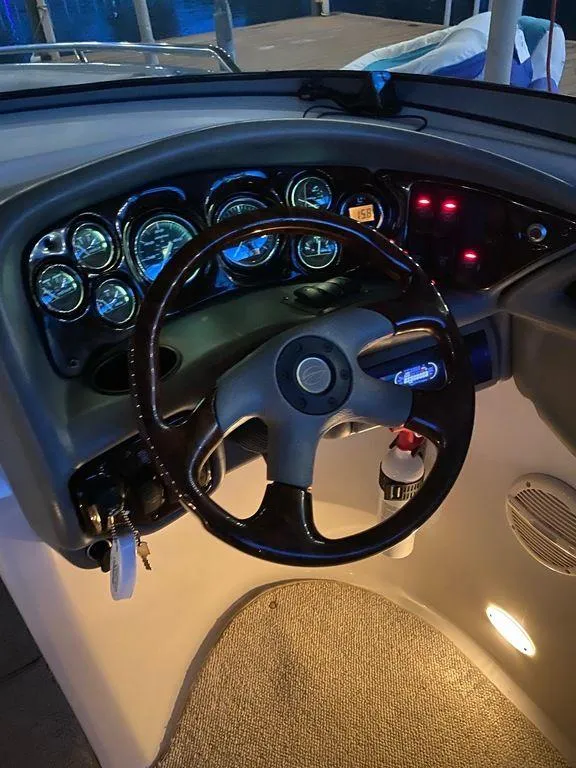 Slide: The Image of 2003 Crownline 270 BR boat dashboard with illuminated gauges and steering wheel. - 20