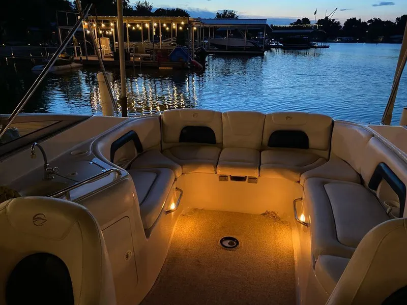 Slide: The Image of 2003 Crownline 270 BR boat interior with cozy evening lighting by the lake. - 25