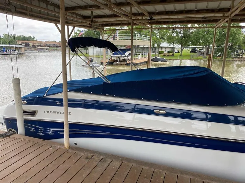 Slide: The Image of 2003 Crownline 270 BR boat docked with blue cover on a lake. - 4